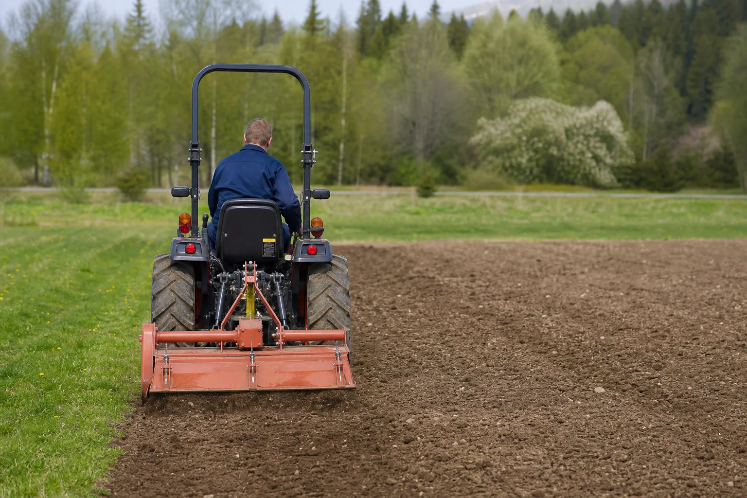 Kompakttraktor bakifrån med varumärkesfri fräs i trepunktslyften.