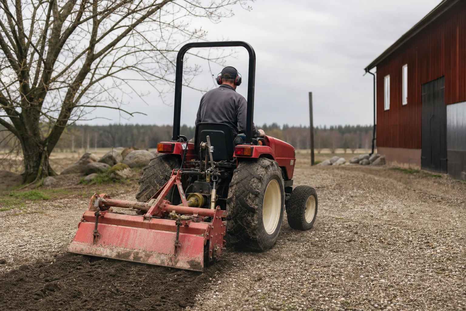 Kompakttraktor bakifrån med varumärkesfri traktorfräs.